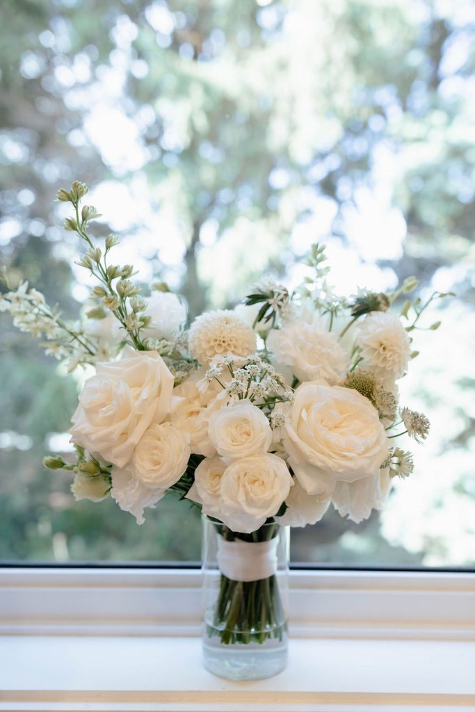White bridal bouquet featuring roses, dahlias and delicate seasonal flowers at Pear Tree Estate.
