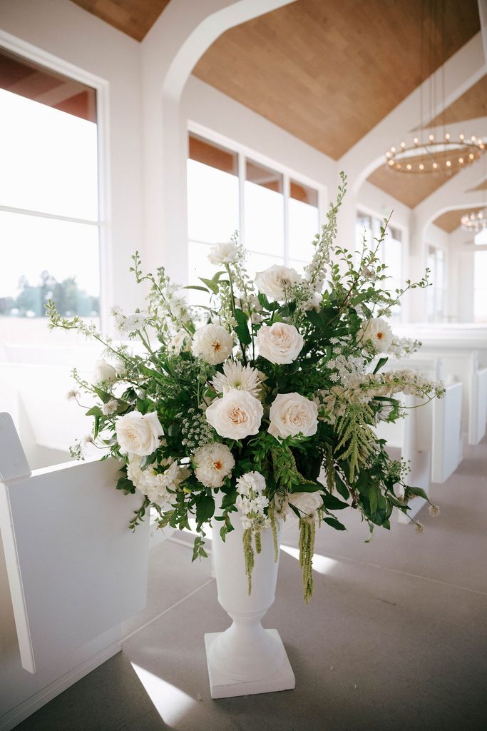 Large white and green floral arrangement in an urn at the Pear Tree Estate wedding ceremony.