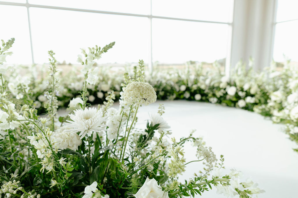 Lush white floral meadow installation with greenery surrounding the ceremony altar at Pear Tree Estate.